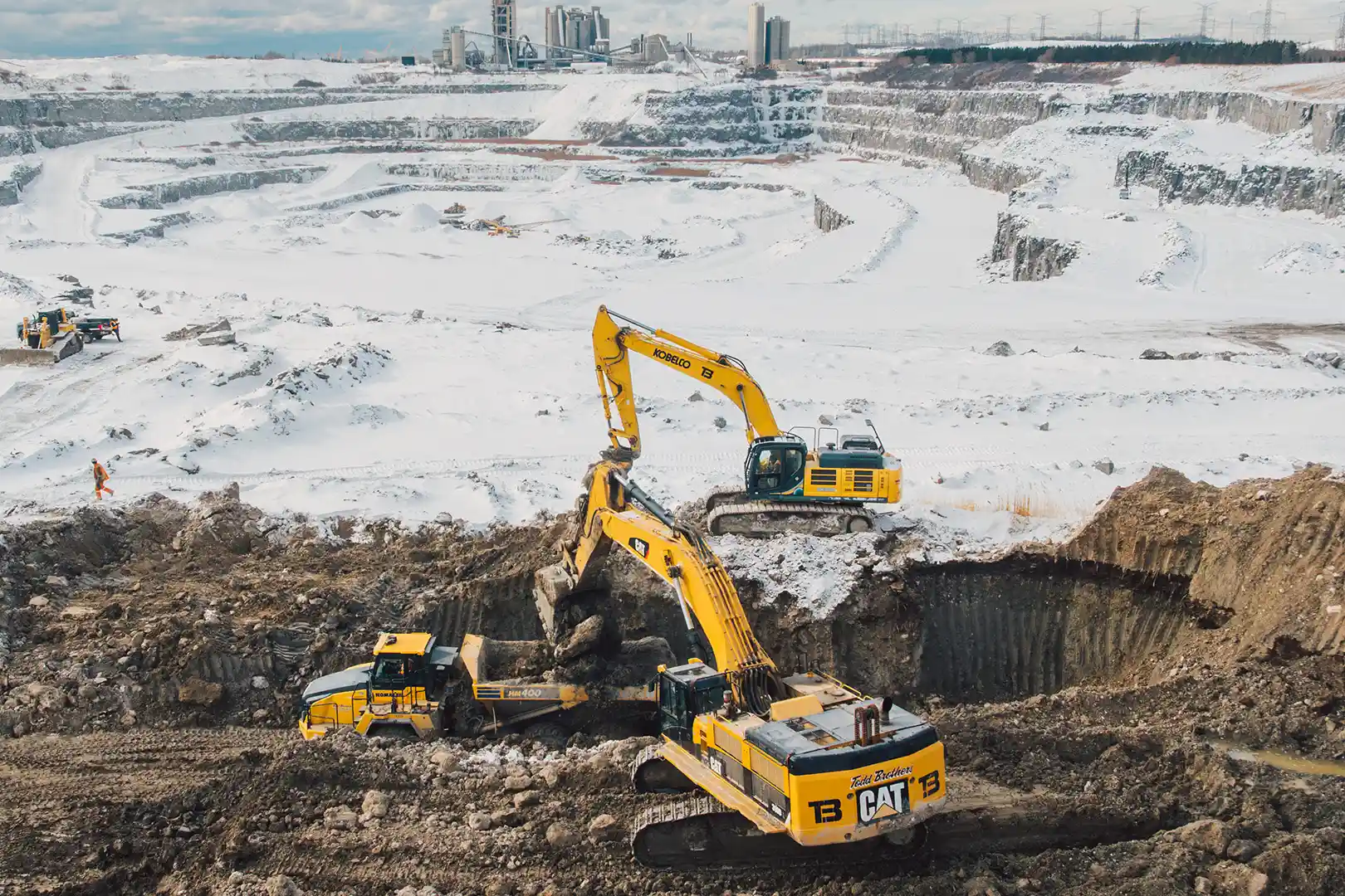 Winter open pit mining with excavators and Volvo haul trucks loading overburden Geraldton area